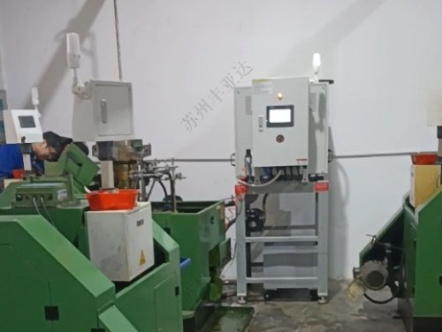 Coolant centrifuge installed beside cold heading machines at a fastener plant