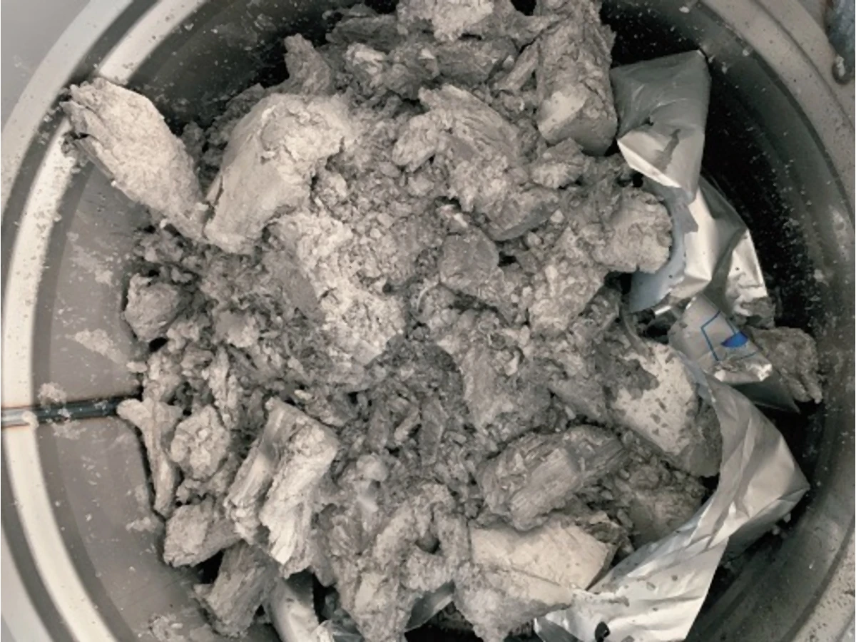 Grey collected solid material in a round container