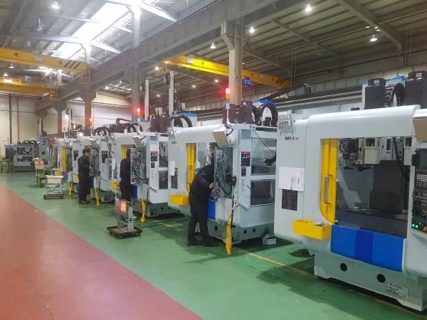 A row of enclosed machine tools in an industrial workshop